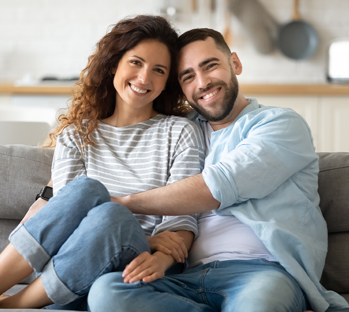 Couple at home smiling after full-arch All-on-4 dental implant treatment in Pompano Beach