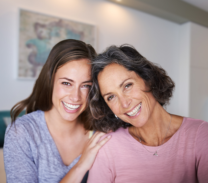 Two patients smiling after single tooth implant treatment at South Florida Smile Spa in Pompano Beach