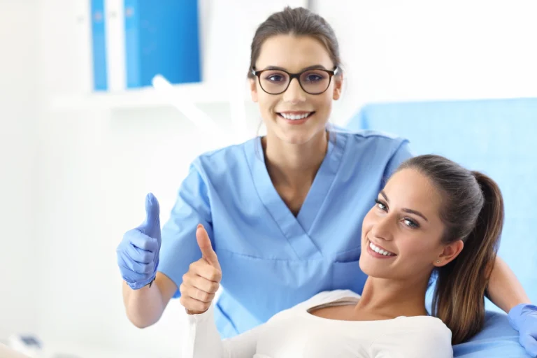 Dental hygienist and patient giving thumbs up.